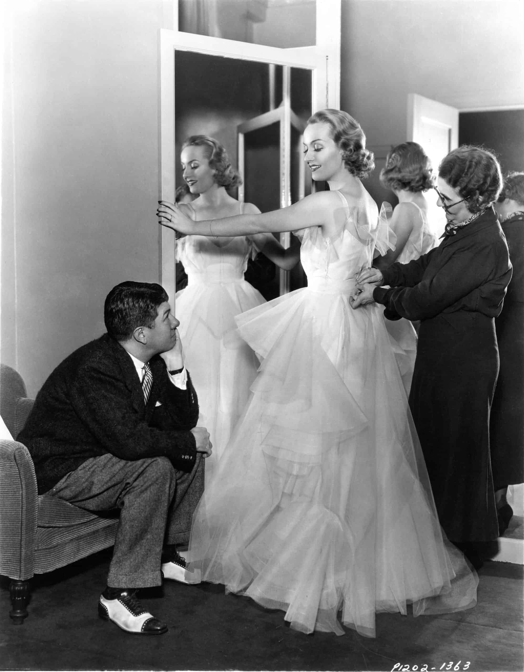 Costume Designer TRAVIS BANTON CAROLE LOMBARD and Assistant MARY O'BRIEN candid fitting dress for THE PRINCESS COMES ACROSS 1936 director WILLIAM K. HOWARD Paramount Pictures. Image shot 1936. Exact date unknown.